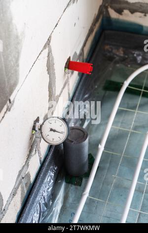 Manometro collegato al tubo dell'acqua per la misurazione della pressione Foto Stock