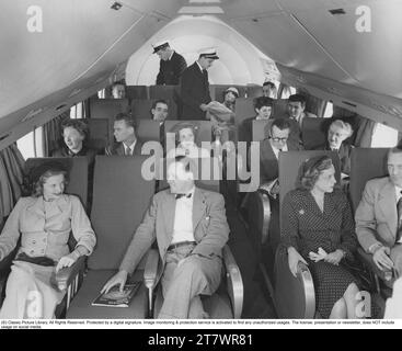 Interno da un aereo appartenente alla compagnia aerea americana Pan American con passeggeri negli anni '1950 Foto Stock