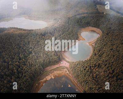 Vista aerea dei laghi Lagoa Empadadas, Lagoa do Eguas e Lagoa Rasa con basse nuvole e foresta di pini, isola di Sao Miguel, isole Azzorre, Portogallo Foto Stock