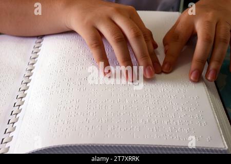 Primo piano sulle mani di una ragazza cieca che legge un libro braille, Center for Blind Children, ho chi Minh City, Vietnam, Indocina, Sud-Est asiatico, Asia Foto Stock