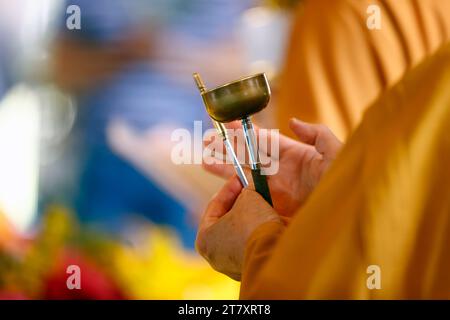 Suora alla cerimonia buddista che suona campana di ottone buddista, tu An tempio buddista, Saint Pierre en Faucigny, alta Savoia, Francia, Europa Foto Stock