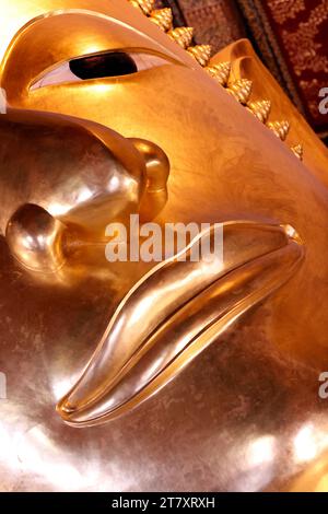 Wat Pho (Tempio del Buddha sdraiato), dettaglio del volto della grande statua dorata reclinata del Buddha (Phra Buddhasaiyas), Bangkok, Thailandia, Sud-Est asiatico Foto Stock