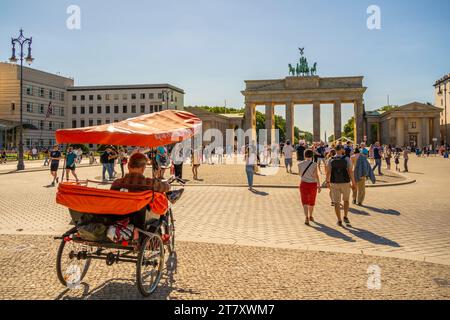 Vista della porta di Brandeburgo, del risciò e dei visitatori di Pariser Platz nelle giornate di sole, Mitte, Berlino, Germania, Europa Foto Stock
