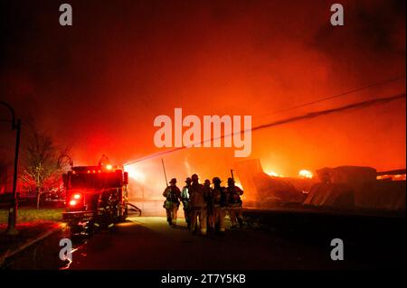 Vigili del fuoco in azione per combattere una fiammata spettacolare presso il Lumberyard RK Miles a Montpelier, Vermont, New England, USA. Foto Stock