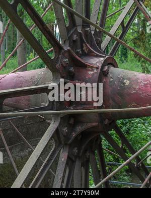 La ruota idraulica in ferro restaurata e funzionante sul fiume Mole a Painshill Park, Cobham, Surrey, Inghilterra, Regno Unito. Foto Stock