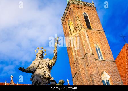 Wrocław, Polonia - 16.11.2023: Monumento a St Giovanni Nepomuco di fronte alla Collegiata della Santa Croce e a San Bartolomeo Foto Stock