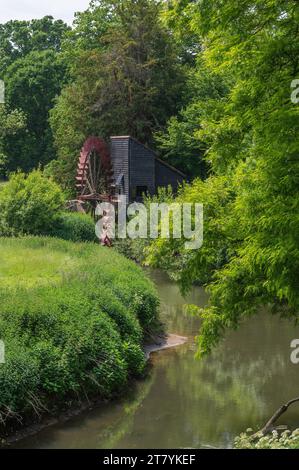 La ruota idraulica in ferro restaurata e funzionante sul fiume Mole a Painshill Park, Cobham, Surrey, Inghilterra, Regno Unito. Foto Stock