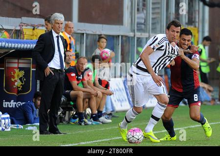 Mario Mandzukic della Juventus FC allontana Nicola Burdisso del Genoa CFC, mentre Giampiero Gasperini capo - allenatore del Genoa CFC li guarda durante il campionato italiano di serie A 2015/2016 tra Genoa CFC e Juventus FC allo Stadio Luigi Ferraris il 20 settembre 2015 a Genova. Foto massimo Cebrelli/DPPI Foto Stock