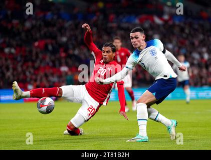 L'inglese Phil Foden (a destra) e il maltese Yannick Yankam si battono per la palla durante la partita del gruppo C di qualificazione UEFA Euro 2024 al Wembley Stadium di Londra. Data immagine: Venerdì 17 novembre 2023. Foto Stock