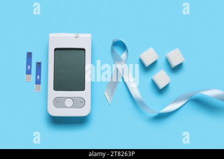 Nastro Awareness con glucometro e zucchero su sfondo blu. Concetto di diabete Foto Stock