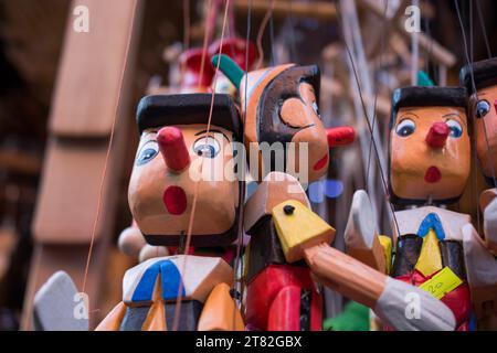 Set di Pinocchio in legno di bambole con il suo naso lungo su sfondo bianco Foto Stock