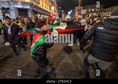 Oslo, Norvegia. 17 novembre 2023. Un attivista è visto marciare e urlare slogan contro la guerra e a favore della liberazione palestinese durante una manifestazione e una marcia che si tiene nelle strade del centro di Oslo. Collettivi e gruppi filo-palestinesi hanno tenuto diverse azioni presso l'edificio del Parlamento nella capitale norvegese, dove hanno chiesto un cessate il fuoco e la cessazione delle ostilità da parte di Israele, che ha effettuato un raid armato sulla Striscia di Gaza. Credito: SOPA Images Limited/Alamy Live News Foto Stock