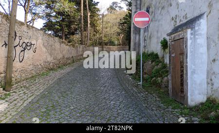 Un segnale stradale che proibisce il traffico su una strada fatta di pietre, pietra, granito nella parte turistica della città di Sintra in Portogallo Foto Stock