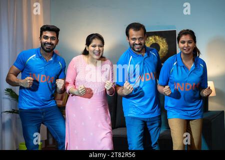 Eccitante famiglia indiana che grida festeggiando la vittoria mentre guardi dal vivo la partita di cricket in tv o in televisione a casa - concetto di appassionati di sport, coppa del mondo Foto Stock
