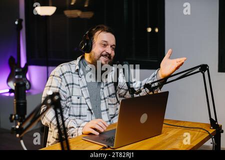 Un blogger online parla in un microfono durante uno streaming. Presentatore radiofonico in studio durante la trasmissione. Foto Stock