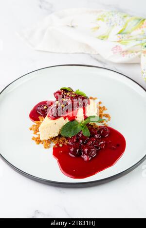 cheesecake condita con marmellata di frutti di bosco e vista laterale alla menta Foto Stock