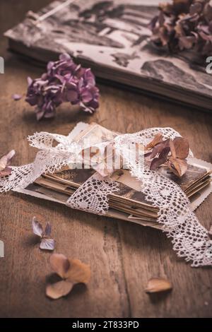 Ricordi, antiche e vecchie foto di famiglia con fiori secchi in stile vintage su un tavolo di legno Foto Stock