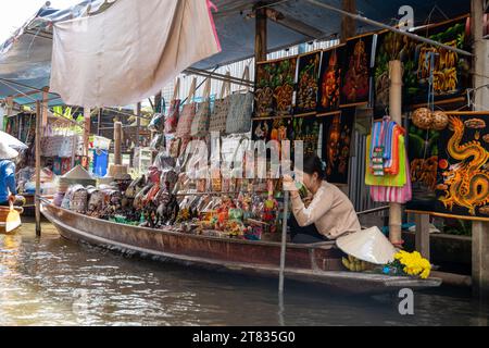 Vari beni, come cibo o bevande tailandesi, sono offerti in vendita su un mercato galleggiante originale Samut Sakhon Thailandia Asia Foto Stock