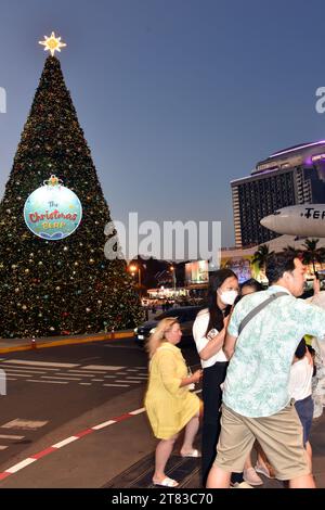 Gli acquirenti fuori dal Terminal 21 Shopping Mall, Pattaya, Thailandia, Sud Est Asiatico; alcuni scattano foto di un aereo con testo al Terminal 21 , 18 novembre 2023. Foto Stock