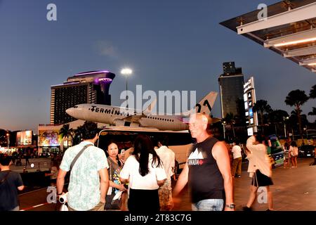 Gli acquirenti fuori dal Terminal 21 Shopping Mall, Pattaya, Thailandia, Sud Est Asiatico; alcuni scattano foto di un aereo con testo del Terminal 21 con un albero di Natale, scattato il 18 novembre 2023. Foto Stock