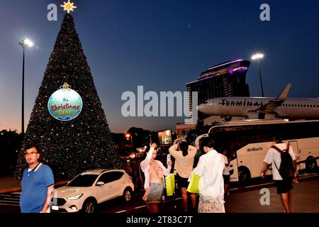 Gli acquirenti fuori dal Terminal 21 Shopping Mall, Pattaya, Thailandia, Sud Est Asiatico; alcuni scattano foto di un aereo con testo al Terminal 21 , 18 novembre 2023. Foto Stock