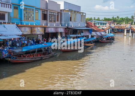 Vari beni, come cibo o bevande tailandesi, sono offerti in vendita su un mercato galleggiante originale Samut Sakhon Thailandia Asia Foto Stock