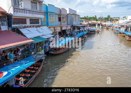 Vari beni, come cibo o bevande tailandesi, sono offerti in vendita su un mercato galleggiante originale Samut Sakhon Thailandia Asia Foto Stock