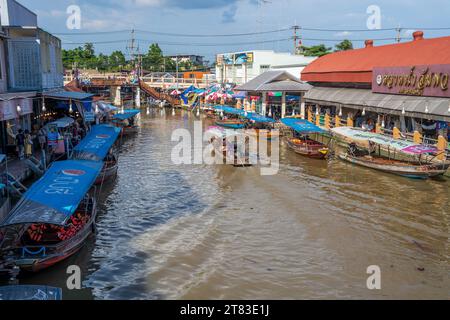 Vari beni, come cibo o bevande tailandesi, sono offerti in vendita su un mercato galleggiante originale Samut Sakhon Thailandia Asia Foto Stock