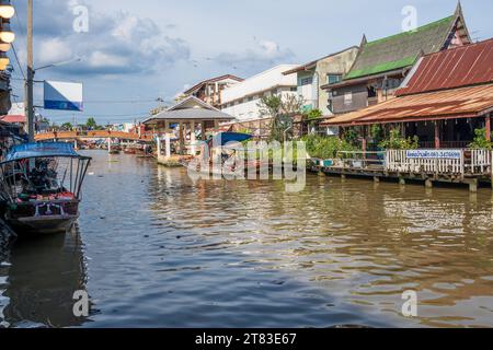 Vari beni, come cibo o bevande tailandesi, sono offerti in vendita su un mercato galleggiante originale Samut Sakhon Thailandia Asia Foto Stock