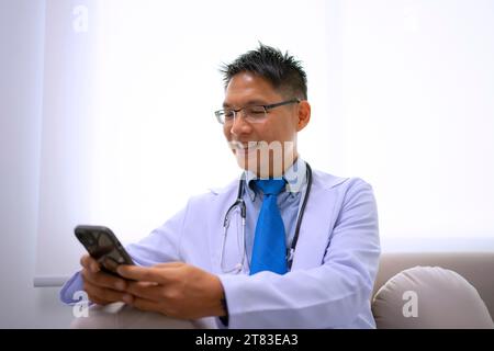 Medico trova informazioni tramite smartphone. Concetto di assistenza sanitaria e tecnologia. Foto Stock