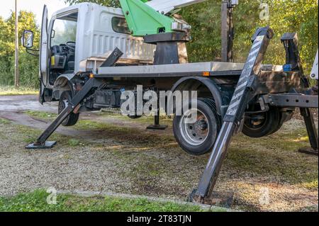 Un carrello con piattaforma aerea è completamente sollevato con quattro stabilizzatori Foto Stock