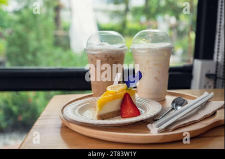Torta al limone con biscotti e caffè ghiacciato su un vassoio di legno nella caffetteria Foto Stock