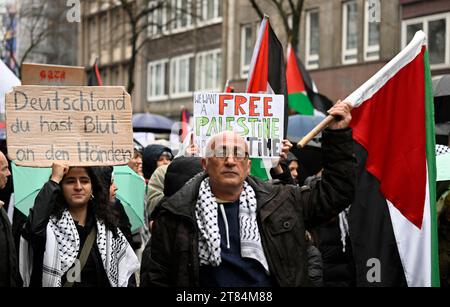 Duesseldorf, Germania. 18 novembre 2023. I manifestanti marciano attraverso la città con i cartelli che recitano "Germania hai sangue sulle mani” e "Palestina libera” e cantano "libertà per la Palestina” per protestare contro la guerra nella Striscia di Gaza. Crediti: Roberto Pfeil/dpa/Alamy Live News Foto Stock