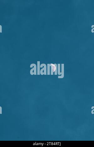 Metà della luna. La superficie lunare è visibile. Cielo azzurro sullo sfondo Foto Stock