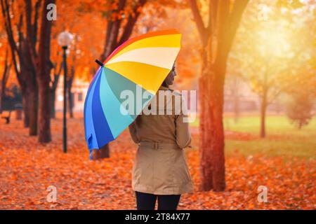 Un ritratto di una bella giovane donna in autunno con ombrello colorato Foto Stock