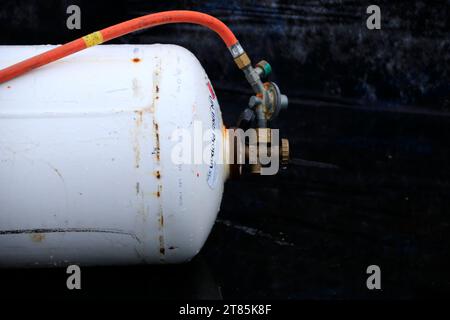 La bombola di gas con valvola senza protezione si trova sul pavimento Foto Stock