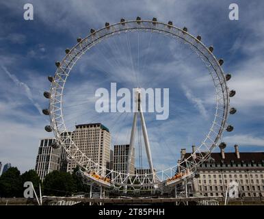 Riprese grandangolari della ruota panoramica del London Eye con capsule passeggeri contro un cielo nuvoloso Foto Stock