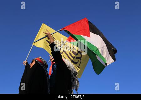 Teheran, Iran. 18 novembre 2023. Due donne iraniane velate sventolano bandiere palestinesi durante un raduno anti-israeliano per mostrare la loro solidarietà al popolo di Gaza in piazza Enqelab-e Eslami (rivoluzione islamica) a Teheran. Migliaia di israeliani e palestinesi sono morti da quando il gruppo militante Hamas ha lanciato un attacco senza precedenti contro Israele dalla Striscia di Gaza il 7 ottobre 2023 e gli scioperi israeliani sull'enclave palestinese che l'ha seguita. (Immagine di credito: © Rouzbeh Fouladi/ZUMA Press Wire) SOLO USO EDITORIALE! Non per USO commerciale! Foto Stock