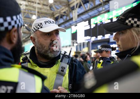 Londra, Regno Unito. 18 novembre 2023. Un agente della polizia ha visto dare ordine verbale ai suoi colleghi alla stazione ferroviaria di Waterloo. I sostenitori pro-palestinesi si sono riuniti alla stazione ferroviaria di Waterloo per protestare contro i palestinesi. Si tratta di una serie di proteste sit-in che si svolgono settimanalmente in diverse importanti stazioni ferroviarie di Londra da quando scoppiò la guerra Israele-Gaza all'inizio di ottobre. (Foto di Hesther ng/SOPA Images/Sipa USA) credito: SIPA USA/Alamy Live News Foto Stock