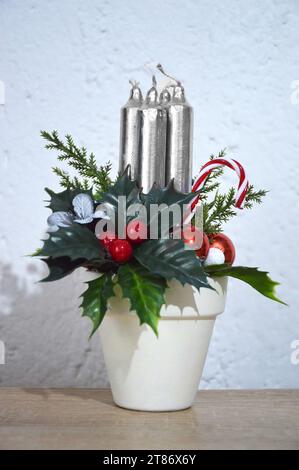 Decorazione natalizia. Candele dell'avvento e decorazioni floreali artificiali sul tavolo. Foto Stock