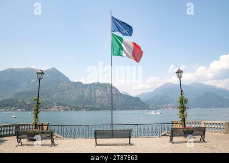 Bellagio Italia porto e passeggiata con bandiere che si muovono al vento in una giornata di sole Foto Stock