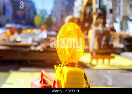 Primo piano della spia gialla arancione di costruzione sulla barricata destinata a mettere in guardia il cantiere. Foto Stock