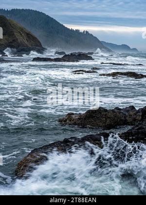 Le onde si infrangono contro le lastre di basalto lungo la costa dell'Oceano Pacifico vicino a Florence, Oregon, Stati Uniti Foto Stock