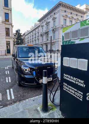 Londra, grande britiano. 11 novembre 2023. Un taxi elettrico di Londra si vede ricaricare in una stazione di St James's Square nel centro di Londra, in Inghilterra, l'11 novembre 2023. Il taxi TX ad alimentazione elettrica è costruito dal costruttore britannico di veicoli commerciali London EV Company (LEVC). (Foto di Samuel Rigelhaupt/Sipa USA) credito: SIPA USA/Alamy Live News Foto Stock