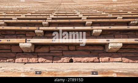 Posti a sedere all'aperto presso un anfiteatro costruito in mattoni rossi e legno. La diminuzione della prospettiva fa sembrare che le file di licenze continuino a essere indefinite Foto Stock