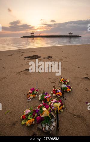 Alba sulla spiaggia sabbiosa di Sanur. Tempio nell'acqua. Offerte in riva al mare sulla spiaggia. Fede indù in Sanur a Bali. Sognare l'isola e sognare Foto Stock