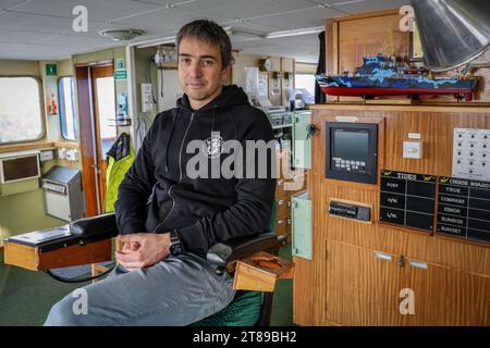 PRODUZIONE - 18 novembre 2023, Brema: Thomas le Coz, capitano della nave d'azione John Paul DeJoria della Captain Paul Watson Foundation, posa sul ponte della sua nave nel porto di Brema. La nave appartiene alla neonata Captain Paul Watson Foundation in Germania, con sede a Delmenhorst, e visiterà Brema il 18 e 19 gennaio. Le parti interessate possono visitare la nave della campagna e parlare con gli attivisti. L'organizzazione internazionale per la conservazione marina Captain Paul Watson Foundation ha istituito una filiale tedesca. La Fondazione Captain Paul Watson in Germania ha sede a Delmenhorst, in bassa Sassonia Foto Stock