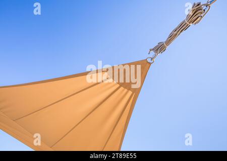 Dettaglio della vela per il sole o delle tende da sole contro il cielo blu soleggiato per il balcone o il patio Foto Stock