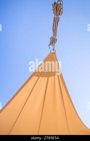 Dettaglio della vela per il sole o delle tende da sole contro il cielo blu soleggiato per il balcone o il patio Foto Stock