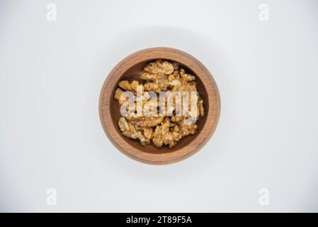 Metà di noce in un recipiente di legno. Semi secchi sgusciati utilizzati come snack o per la cottura. Primo piano, Foto Stock